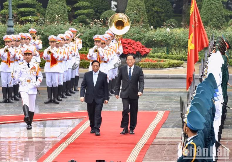 El premier vietnamita y su homólogo laosiano pasan revista a la guardia de honor. El premier vietnamita y su homólogo laosiano pasan revista a la guardia de honor.