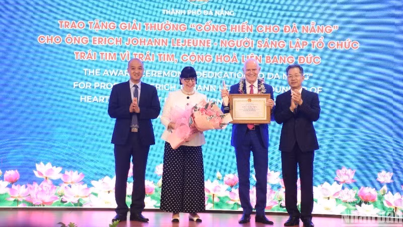 El secretario del Comité del Partido Comunista en Da Nang, Nguyen Van Quang, otorga el premio “Dedicación a Da Nang” al profesor Erich Johann Lejeune. (Fotografía: Anh Dao)