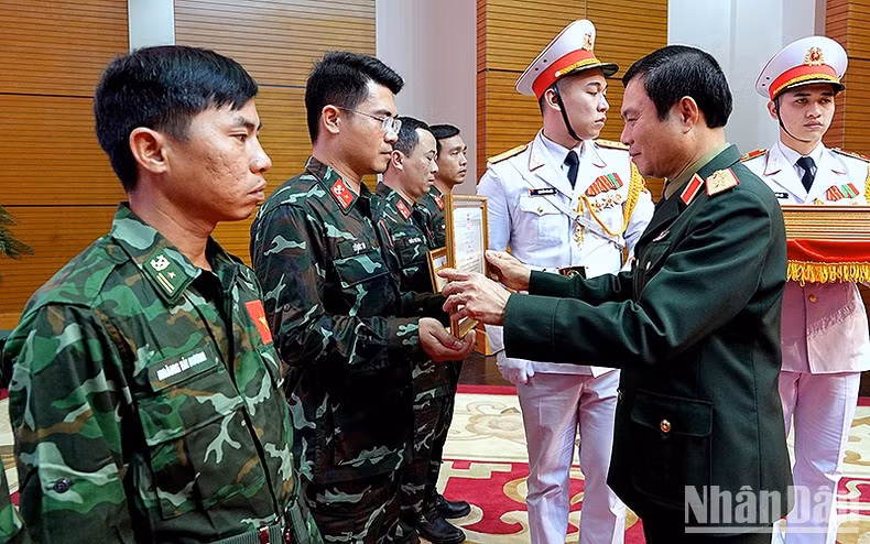 El coronel general Nguyen Tan Cuong otorga el Certificado de Reconocimiento del Ministro de Defensa a los miembros de la delegación.