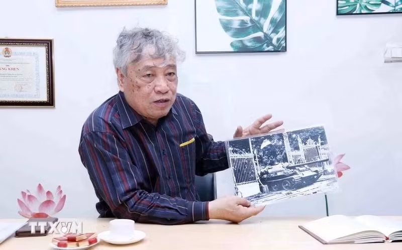 El periodista Tran Mai Huong con la foto titulada "El tanque del Ejército de Liberación entra al Palacio de Independencia al mediodía del 30 de abril de 1975". (Fotografía: VNA)