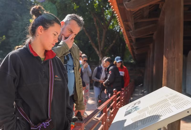 Visitantes buscan información en el jardín de la Estela de los Doctores.