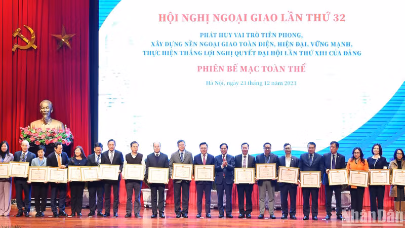El canciller Bui Thanh Son entrega certificados de mérito a personas y colectivos por sus desempeño en tareas diplomáticas. (Fotografía: Nhan Dan)