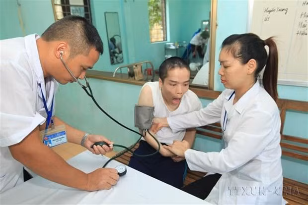 Los empleados médicos realizan la atención médica para la persona afectada por el Agente Naranja en el Centro de Atención, Nutrición y Tratamiento de Víctimas de esa química tóxica en Hanói. (Fotografía: VNA)