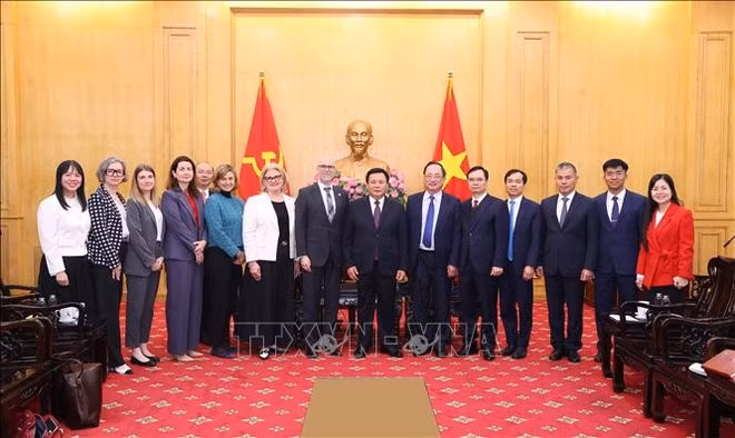 El director de la Academia Nacional de Política Ho Chi Minh, Nguyen Xuan Thang, y el embajador canadiense, Shawn Steil, junto con los delegados (Foto: VNA)