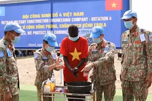 Médicos y personal sanitario militar vietnamitas enseñan a estudiantes locales los procedimientos de desinfección conforme a los protocolos médicos. (Foto: Nhan Dan)