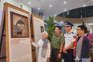 La ex prisionera política Le Tu Cam se emociona al contemplar su retrato digitalizado, recreado y elaborado con hojas de loto, expuesto en el Museo de Con Dao. (Foto: qdnd.vn)