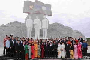 La delegación deposita flores ante las estatuas de los presidente Ho Chi Minh, Phomvihane y Souphanouvong en el Parque de la Amistad Laos-Vietnam, en Vientián. (Foto: Nhan Dan)