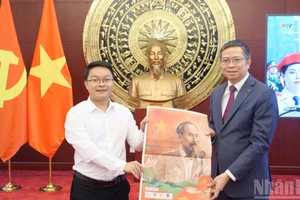 El representante de la corresponsalía del periódico Nhan Dan en China entrega el suplemento especial al embajador de Vietnam en Pekín, Pham Thanh Binh.