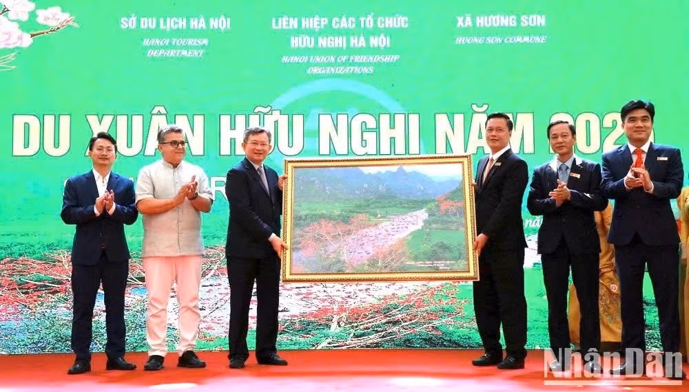 Representantes de la comuna de Huong Son ofrecen a la delegación una pintura del arroyo Yen en el conjunto paisajístico de Huong Son.