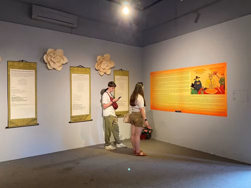 Numerosos visitantes extranjeros recorren la exposición para conocer mejor la vida cotidiana y las celebraciones del Tet Doan Ngo en la antigua corte vietnamita.