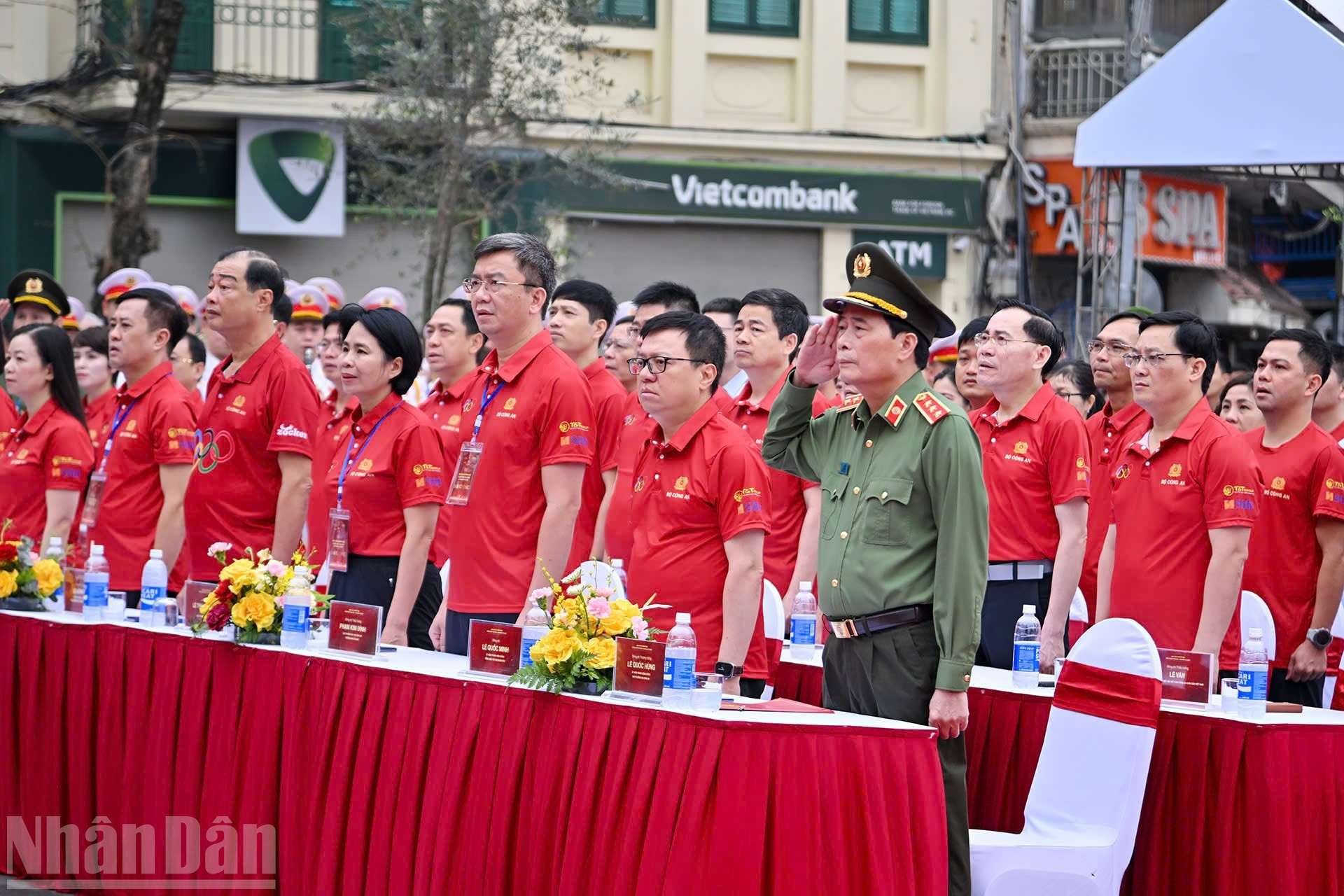 Delegados y participantes realizan el saludo a la bandera nacional en la ceremonia.
