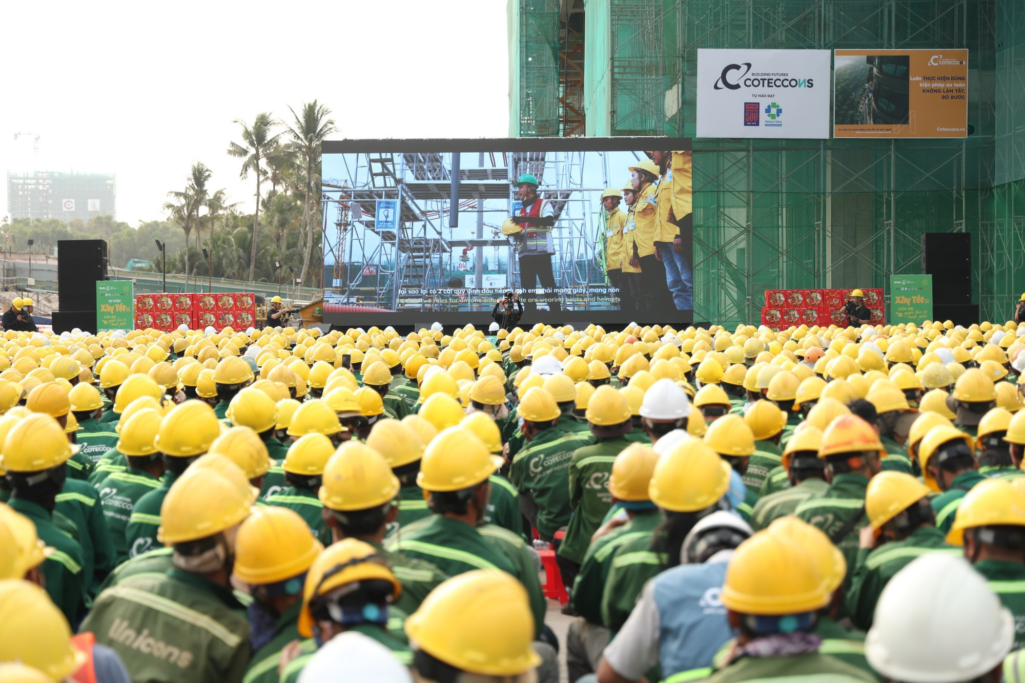 Los obreros observan un video de concienciación sobre seguridad laboral en la obra.