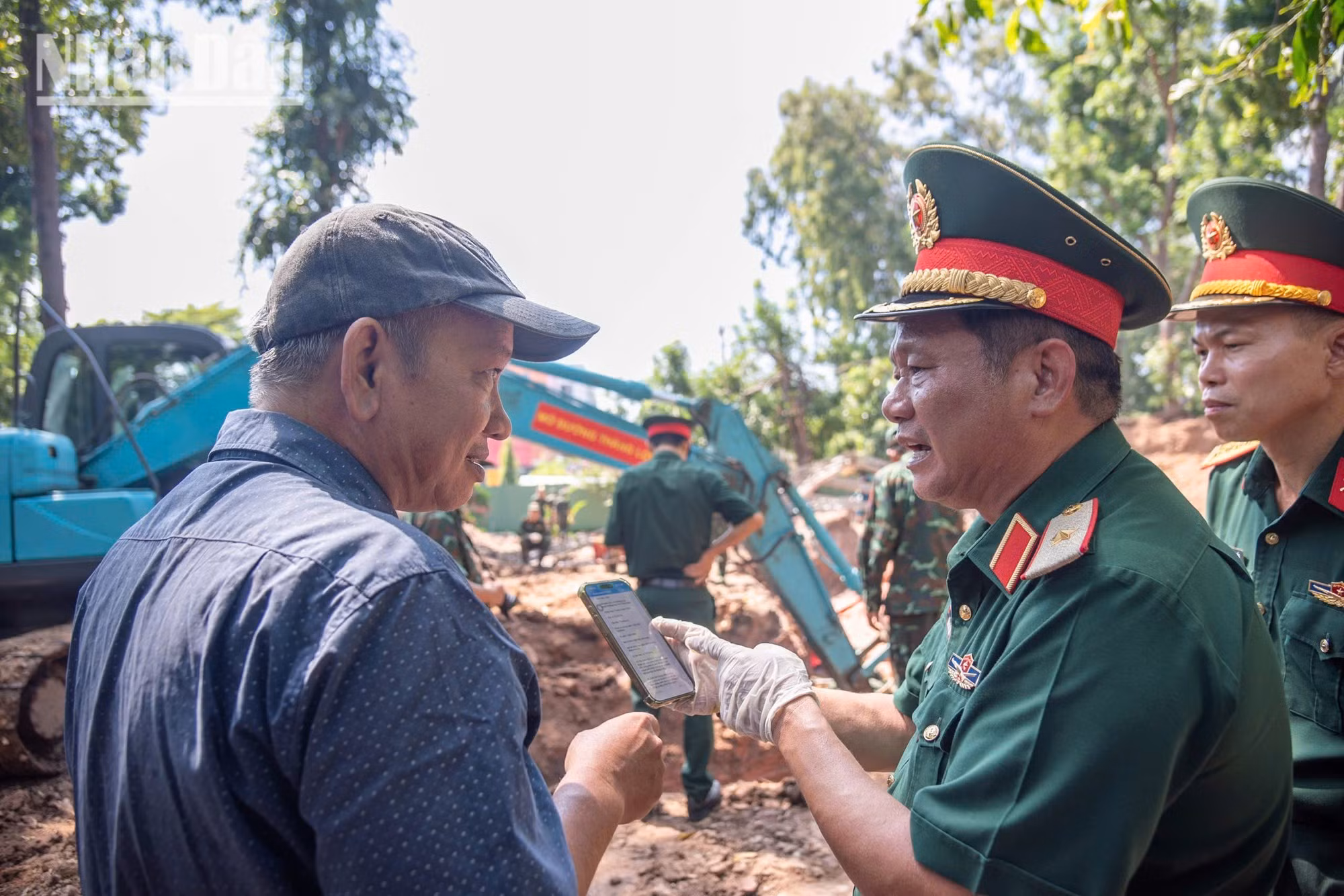 El mayor general Tran Chi Tam intercambia información con el arquitecto Nguyen Xuan Thang, integrante del grupo de expertos encargado de la investigación histórica.