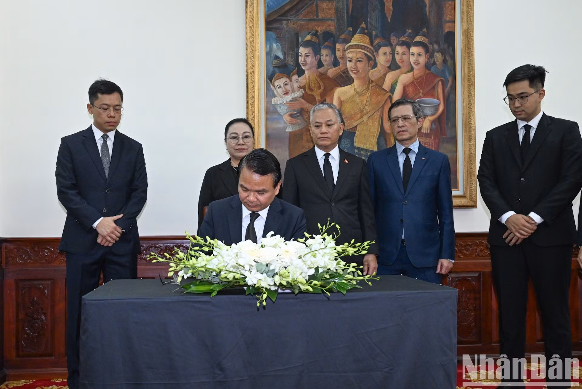 El ministro y jefe de la Oficina del Gobierno, Dang Xuan Phong, firma el libro de condolencias y rinde homenaje al presidente de la Asamblea Nacional de Laos, Saysomphone Phomvihane.