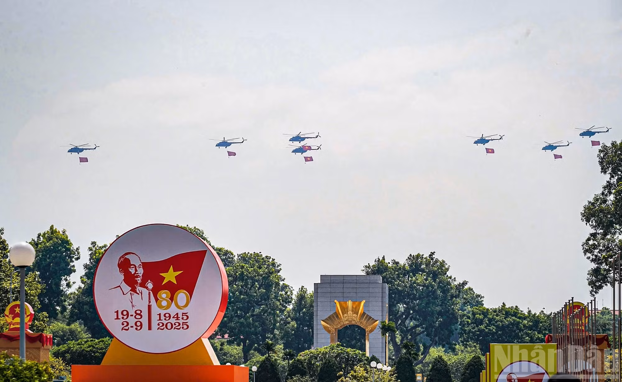 Las formaciones portan las banderas de la Patria y del Partido sobre la calle Hoang Dieu.