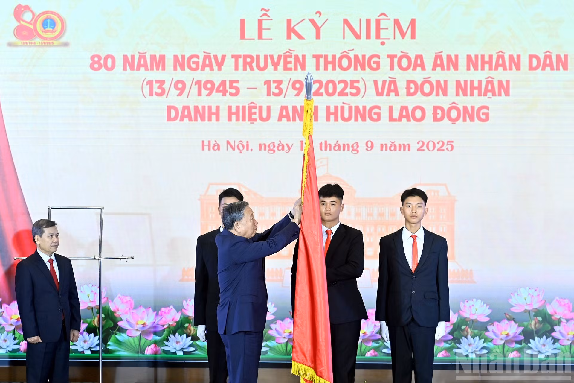 To Lam coloca el título de Héroe del Trabajo en la bandera tradicional del sector del Tribunal popular.