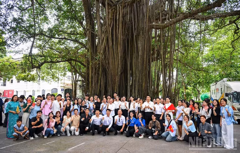 Los artistas y asistentes se toman foto de recuerdo en la sede de Nhan Dan.