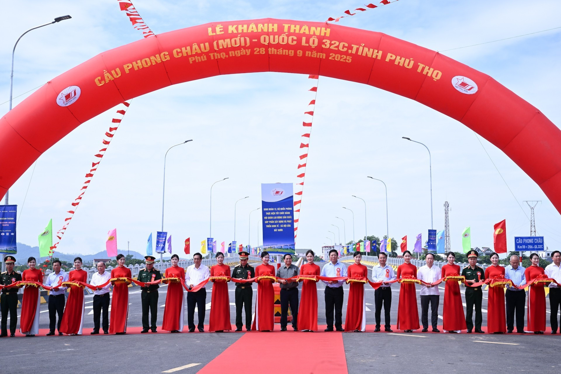 El primer ministro Pham Minh Chinh y los delegados cortan la cinta de inauguración del puente Phong Chau.