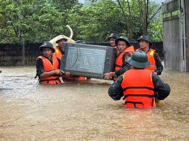 Oficiales y soldados de la Brigada 409 y del Alto Mando Militar de la provincia de Bac Ninh ayudan a los habitantes de la comuna de Xuan Luong a trasladar personas y bienes. (Foto: VNA)