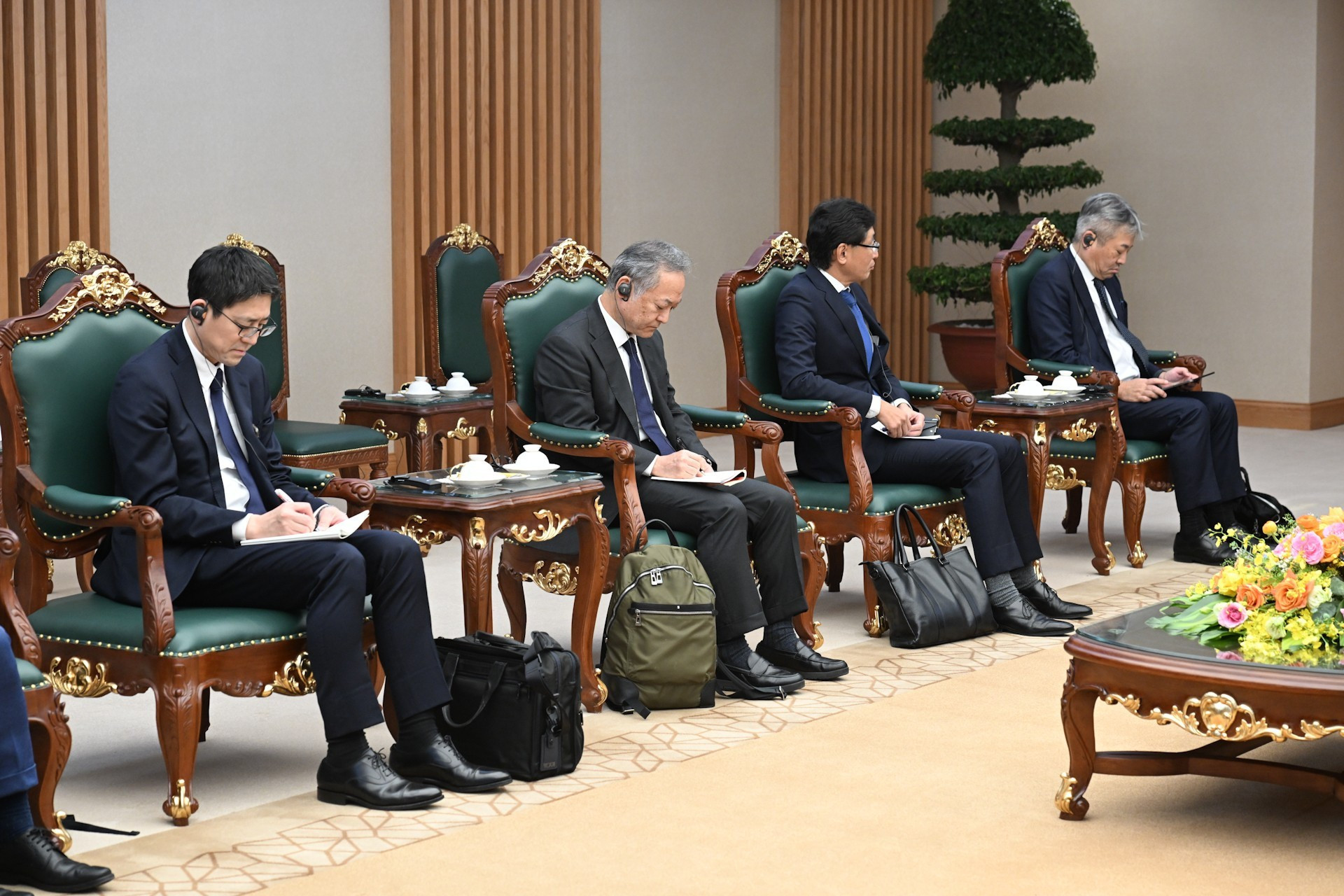 Los miembros de la delegación que acompaña a Hori Kenichi participan en la reunión.