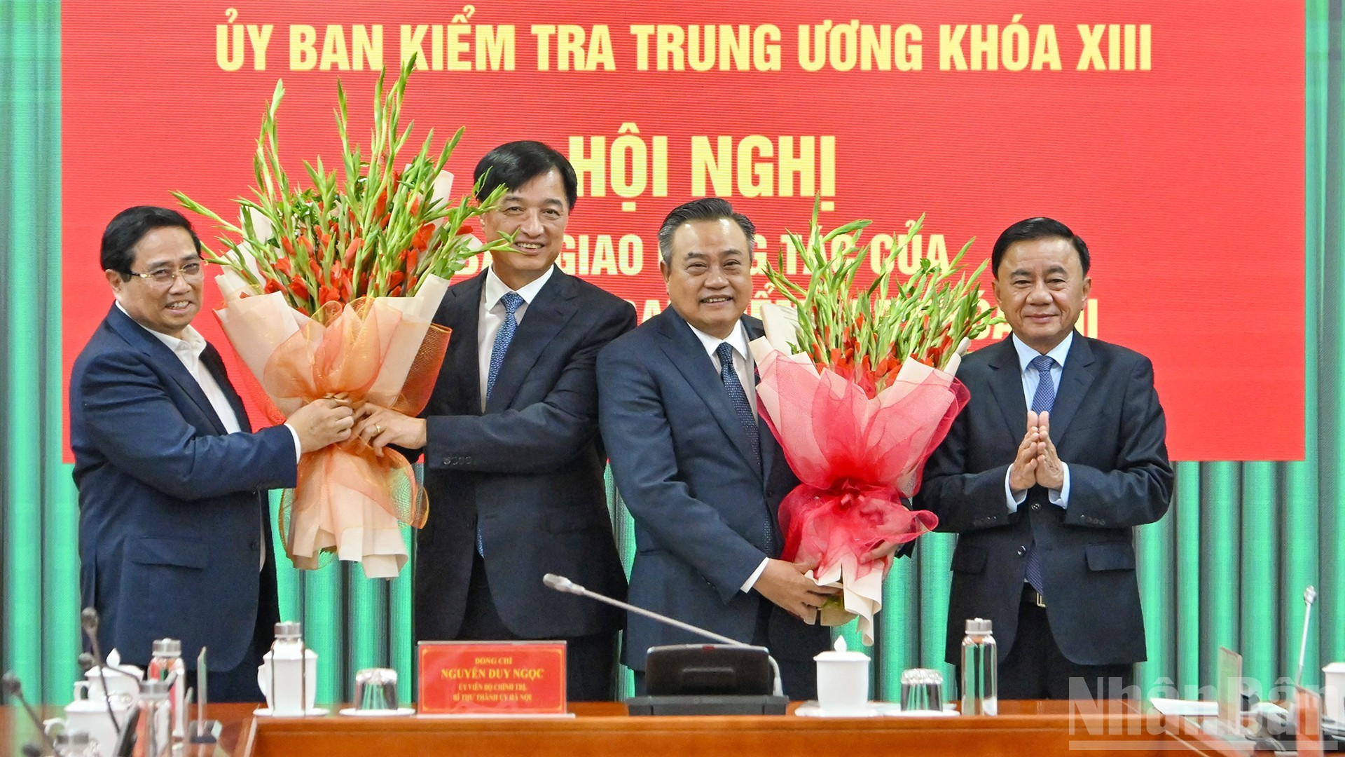 El primer ministro Pham Minh Chinh y el permanente del Secretariado del PCV, Tran Cam Tu, entregan flores para felicitar al secretario del Comité del Partido de Hanói, Nguyen Duy Ngoc, y al jefe de la Comisión de Control Disciplinario del Comité Central del PCV, Tran Sy Thanh.