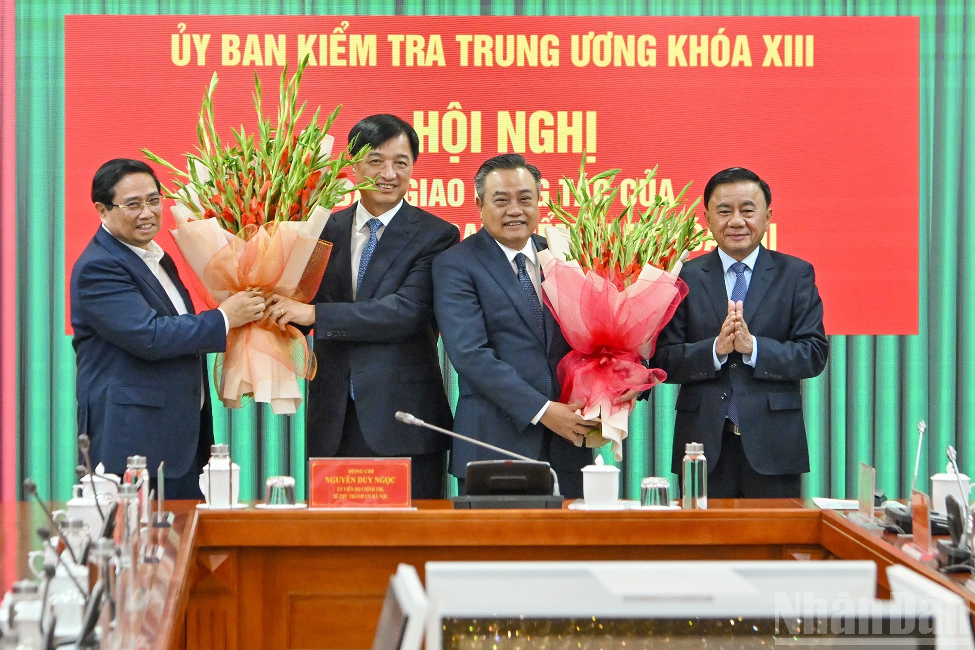 El primer ministro Pham Minh Chinh y el permanente del Secretariado del PCV, Tran Cam Tu, entregan flores para felicitar al secretario del Comité del Partido de Hanói, Nguyen Duy Ngoc, y al jefe de la Comisión de Control Disciplinario del Comité Central del PCV, Tran Sy Thanh.