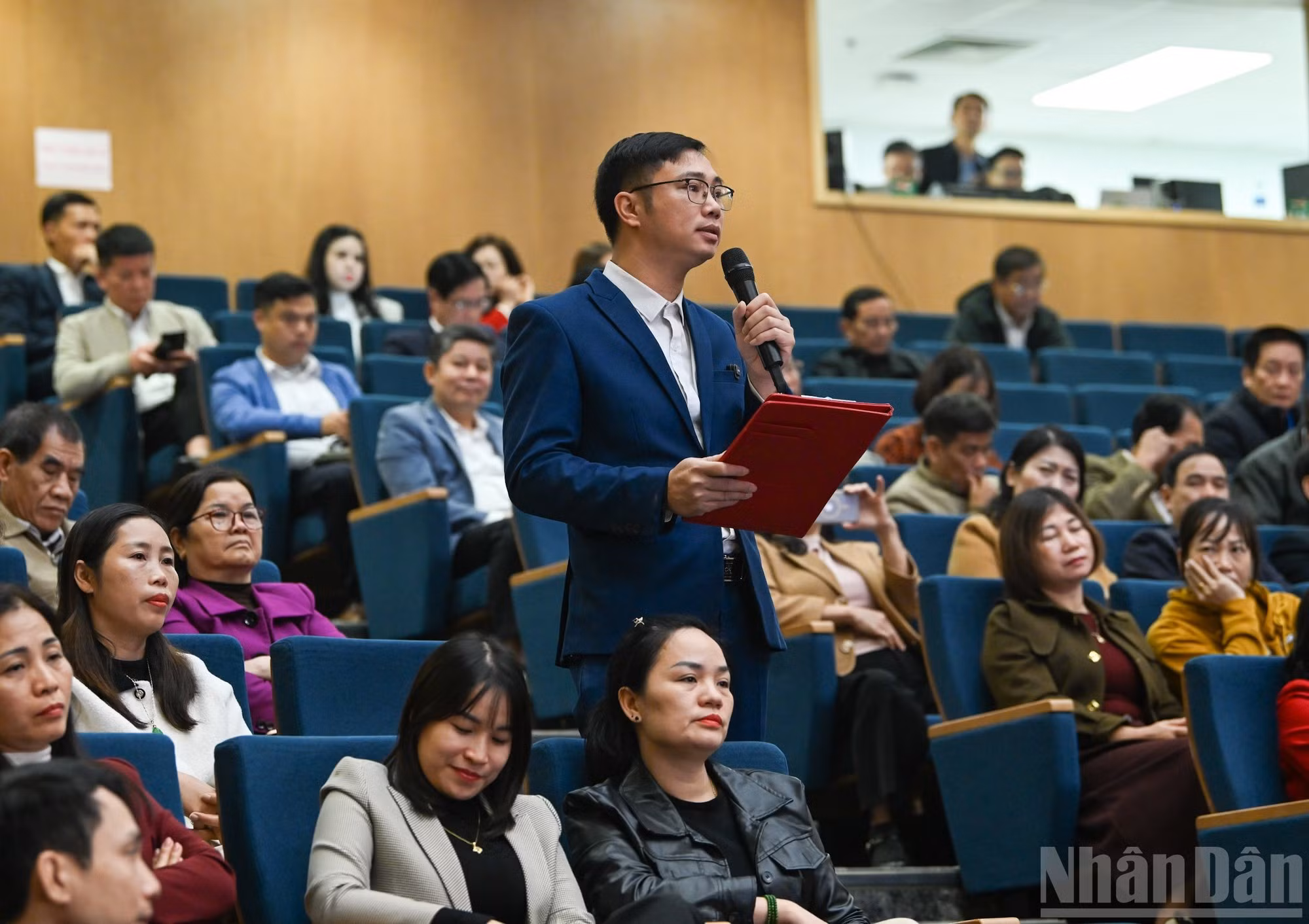 Thai Chi Nguyen, votante en el barrio Au Lau, expresa sus opiniones y propuestas en la conferencia.