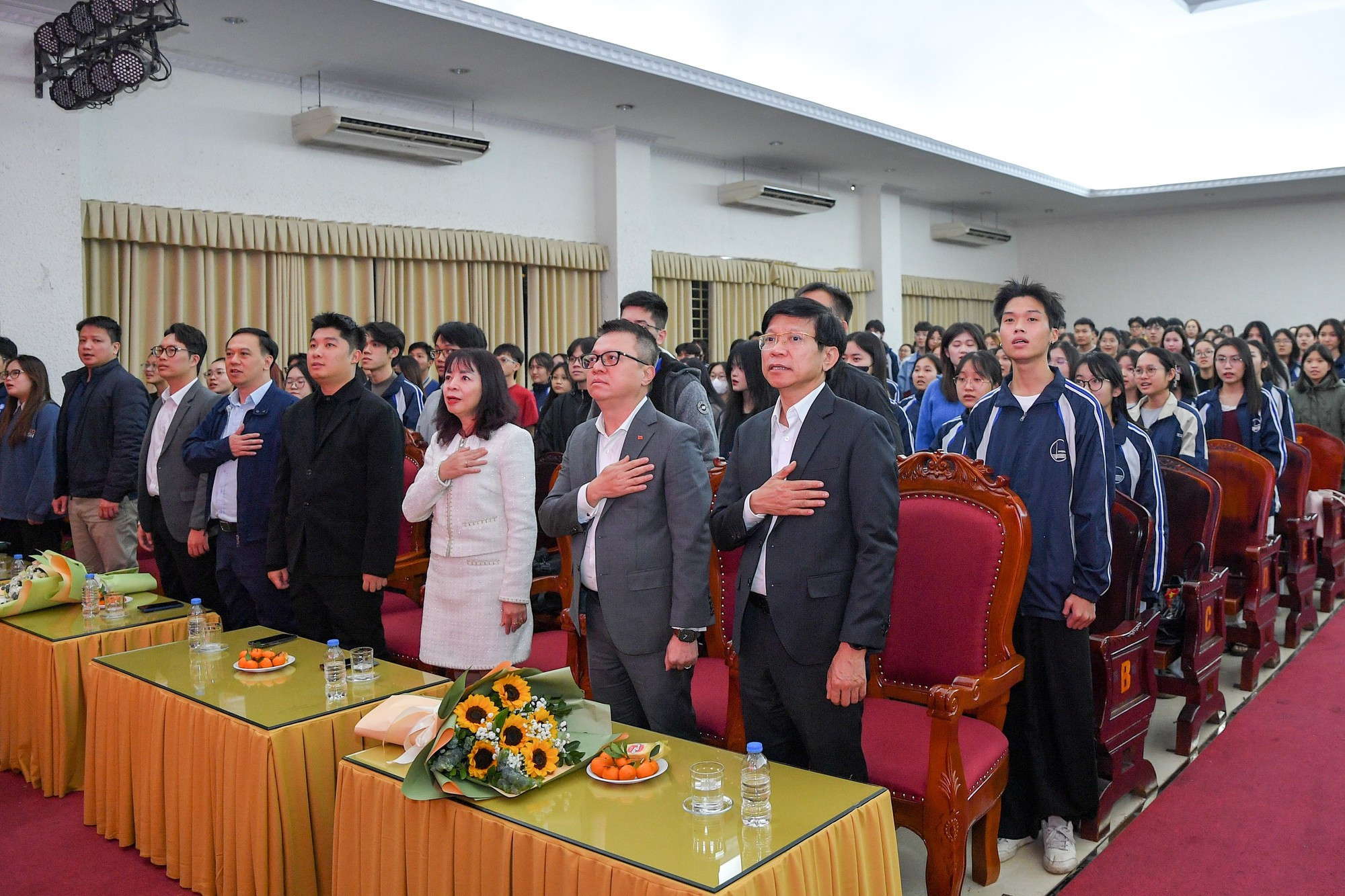 Delegados y estudiantes realizan la ceremonia de saludo a la bandera nacional.