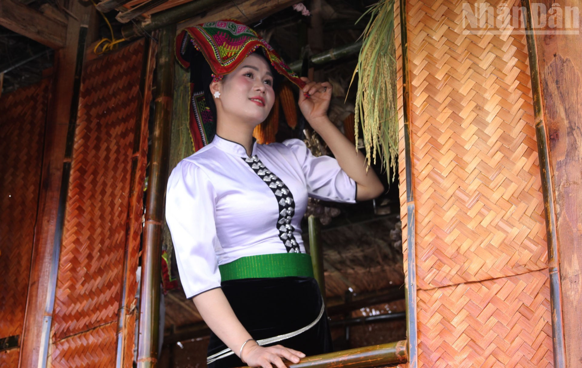 Ca Thi Xom, engalanada con un traje tradicional de la etnia thai negra, posa en el balcón de la casa sobre pilotes del espacio cultural Lao-Khmu. Ca Thi Xom, engalanada con un traje tradicional de la etnia thai negra, posa en el balcón de la casa sobre pilotes del espacio cultural Lao-Khmu.