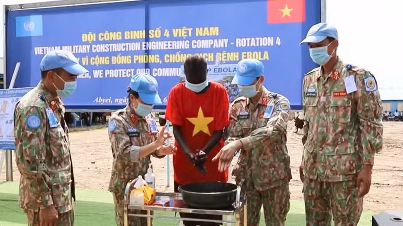 Médicos y personal sanitario militar vietnamitas enseñan a estudiantes locales los procedimientos de desinfección conforme a los protocolos médicos. (Foto: Nhan Dan)