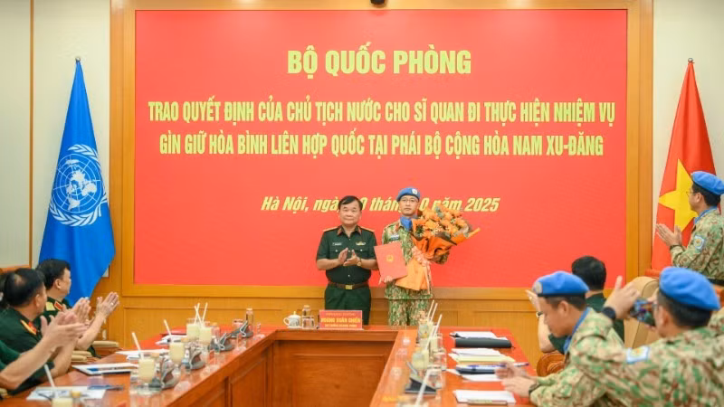 El miembro del Comité Central del Partido Comunista de Vietnam y viceministro de Defensa, teniente general Hoang Xuan Chien, entrega la decisión del Presidente de la República al oficial designado a una misión de mantenimiento de la paz de la Organización de las Naciones Unidas. (Foto: Nhan Dan)