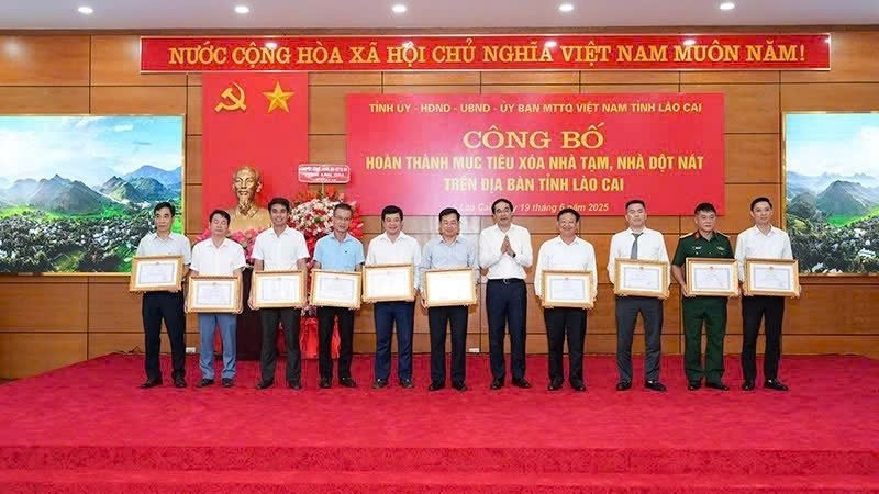 El secretario del Comité del Partido de la provincia de Lao Cai, Trinh Xuan Truong, otorga Certificados de Mérito a las entidades y localidades con logros sobresalientes en la eliminación de viviendas temporales y deterioradas. (Foto: Nhan Dan)