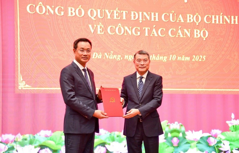 Le Minh Hung, (derecha) miembro del Buró Político, secretario del Comité Central del PCV y jefe de su Comisión de Organización, presenta la decisión del nombramiento a Le Ngoc Quang. (Foto: VGP)