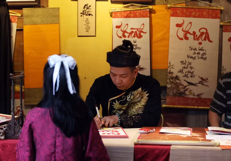 Turistas visitan y aprenden sobre las costumbres tradicionales del Tet del pueblo vietnamita.