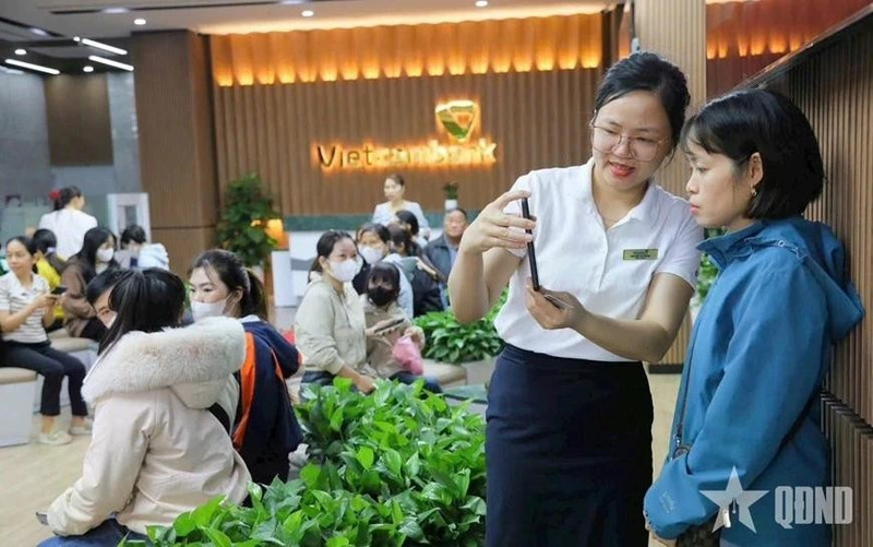 El personal de Vietcombank guía a los clientes a través del proceso biométrico. (Foto: qdnd.vn)
