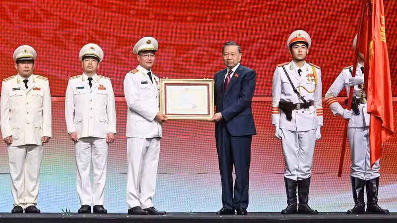 El secretario general del Partido Comunista y presidente de Vietnam, To Lam, entrega la Orden de la Estrella de Oro a la Fuerza de Seguridad Popular. (Foto: Nhan Dan)