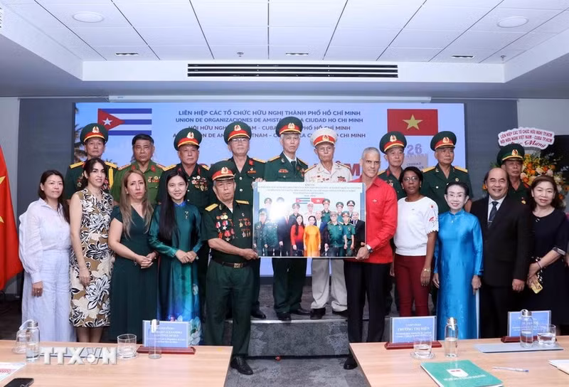 Representantes del comité de enlace de veteranos del Batallón 261 - Giron en Ciudad Ho Chi Minh presentan una foto conmemorativa a Mauricio Alejandro Martínez Duque, cónsul general de Cuba en la ciudad. (Foto: VNA)
