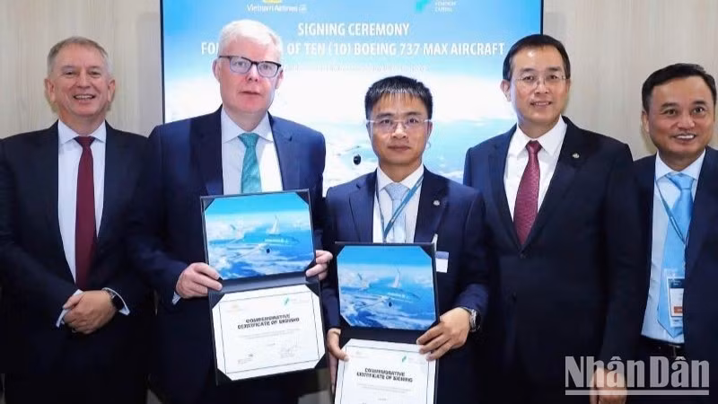 El vicepresidente ejecutivo de Vietnam Airlines, Nguyen Chien Thang (izquierda), y Paul Geaney, presidente y director comercial de Avolon, sostienen el certificado de la firma del acuerdo para el arrendamiento de aviones Boeing 737 MAX adicionales en Farnborough, Reino Unido, el 21 de julio. (Foto: Nhan Dan)
