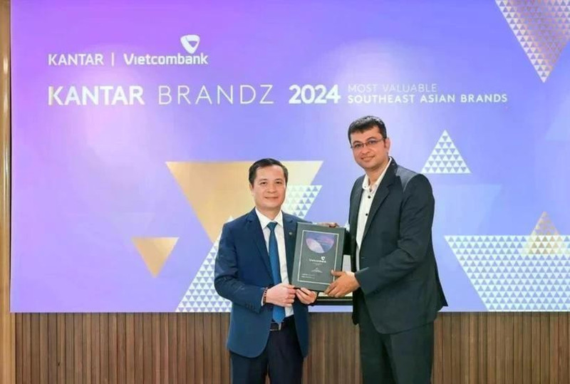 Le Hoang Tung, subdirector general de Vietcombank (izquierda), recibe el certificado de Sumit Kamra, director de desarrollo estratégico de Kantar Insights. (Foto: VNA)