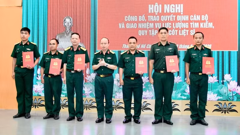 El coronel Nguyen Dinh Chuan, comisario político adjunto del Alto Mando Militar municipal y subdirector del Comité Directivo 515 de Ciudad Ho Chi Minh, entrega las decisiones para la asignación de personal a la fuerza especializada encargada de la búsqueda y la recuperación de los restos de los soldados caídos. (Foto: Nhan Dan)