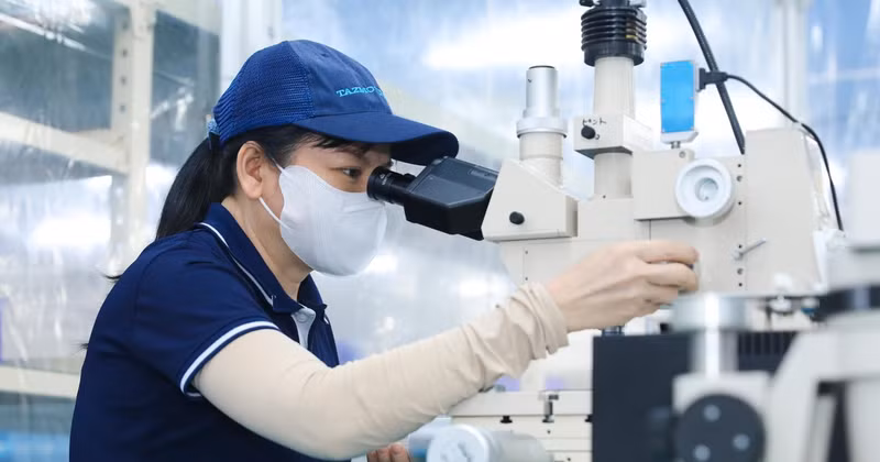 Trabajadores ensamblan componentes ultrapequeños que requieren una alta precisión para la producción de chips semiconductores. Foto: VNA