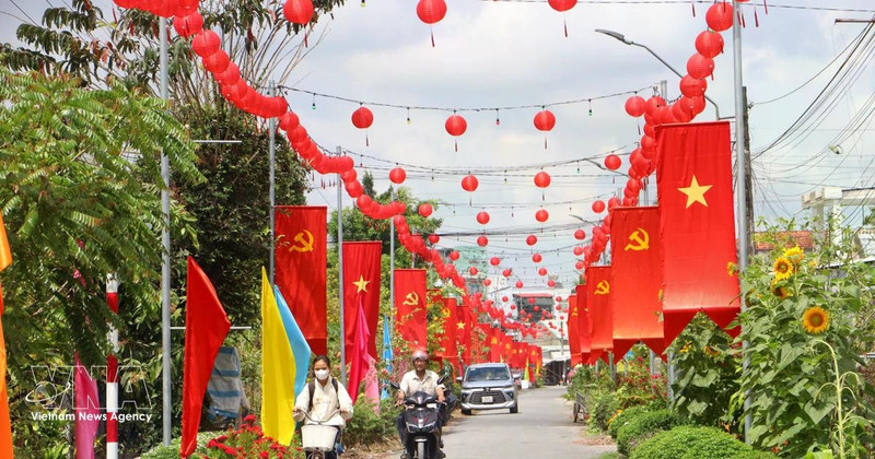 Una carretera rural en la comuna de Tra Con, provincia de Vinh Long, engalanada con banderas y flores, refleja el ambiente festivo y de expectación ante la próxima jornada electoral. (Foto: VNA)