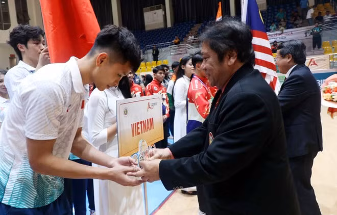 Teddy Suratmadji, secretario general de la Federación Mundial de Pencak Silat, entrega copa conmemorativa a la delegación vietnamita. (Foto: VNA)