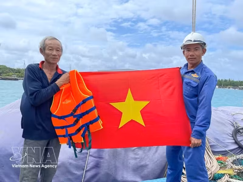 La armada entrega banderas nacionales a los pescadores. Foto: VNA