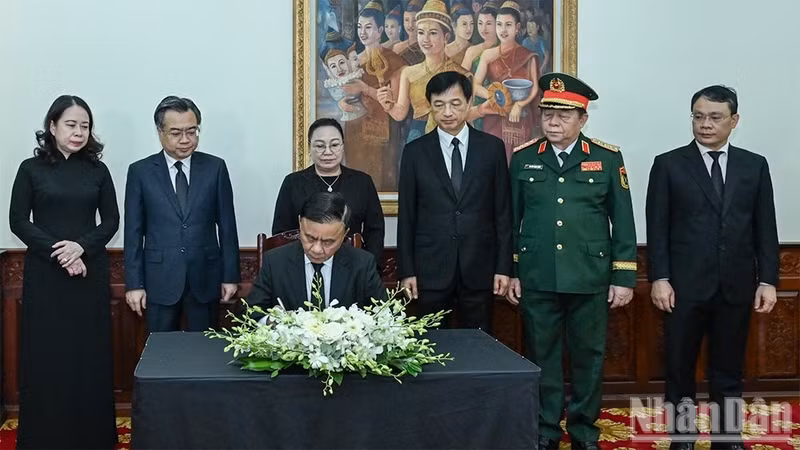 El miembro del Buró Político e integrante permanente del Secretariado del Comité Central del Partido Comunista de Vietnam, Tran Cam Tu, firma el libro de condolencias por el fallecimiento del presidente de la Asamblea Nacional de Laos, Xaysomphone Phomvihane. (Foto: Nhan Dan)