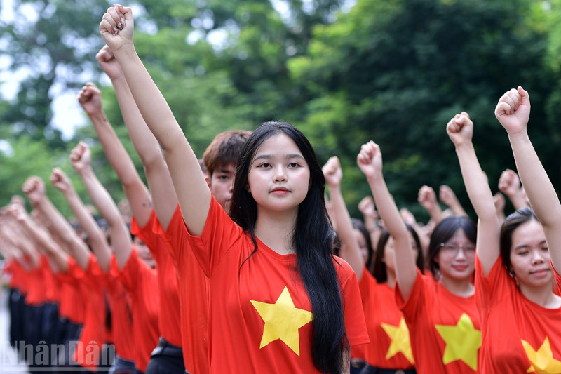 Jóvenes vietnamitas organizan simultáneamente ceremonia de saludo a la bandera 'Amo a mi Patria'. (Foto: Nhan Dan)