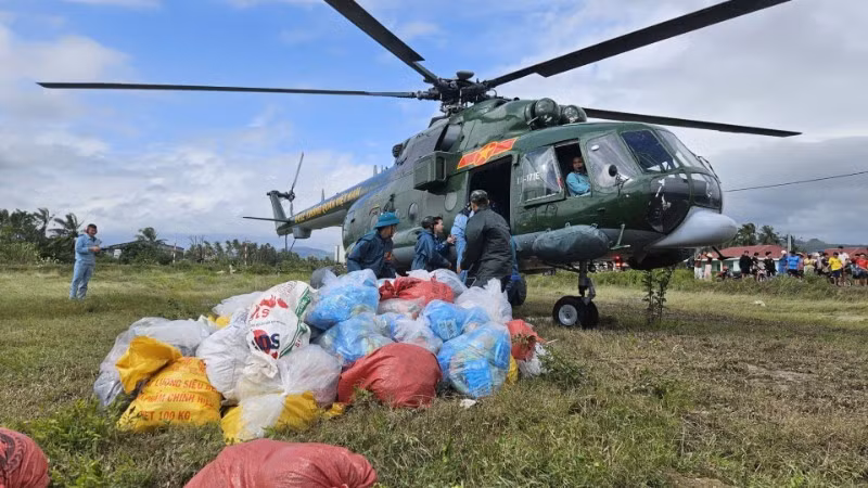Un helicóptero militar lanza suministros de socorro a una zona afectada por las inundaciones. (Foto: Nhan Dan)