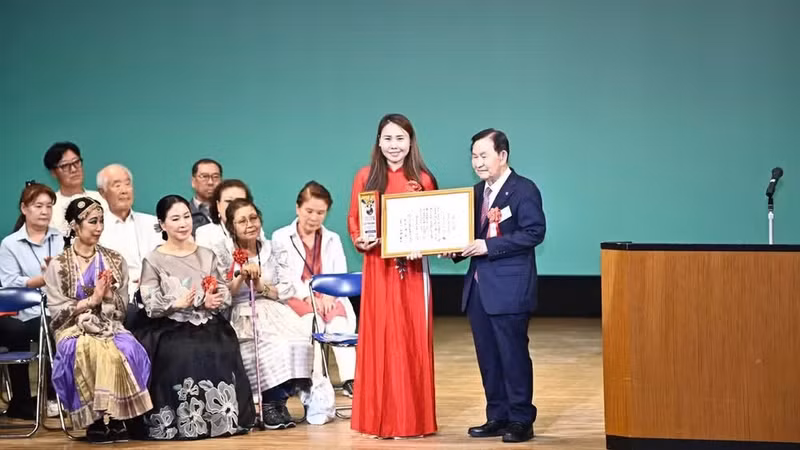 El representante de la Organización de Amistad Internacional de Japón entrega el premio comunitario Ciudadano Global a Le Thuong, presidenta de la Asociación de Vietnamitas de la región de Kansai.