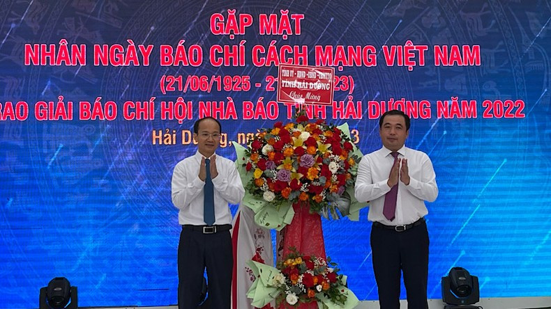 El secretario del Comité Provincial del Partido, Tran Duc Thang, entrega flores para felicitar a los periodistas.