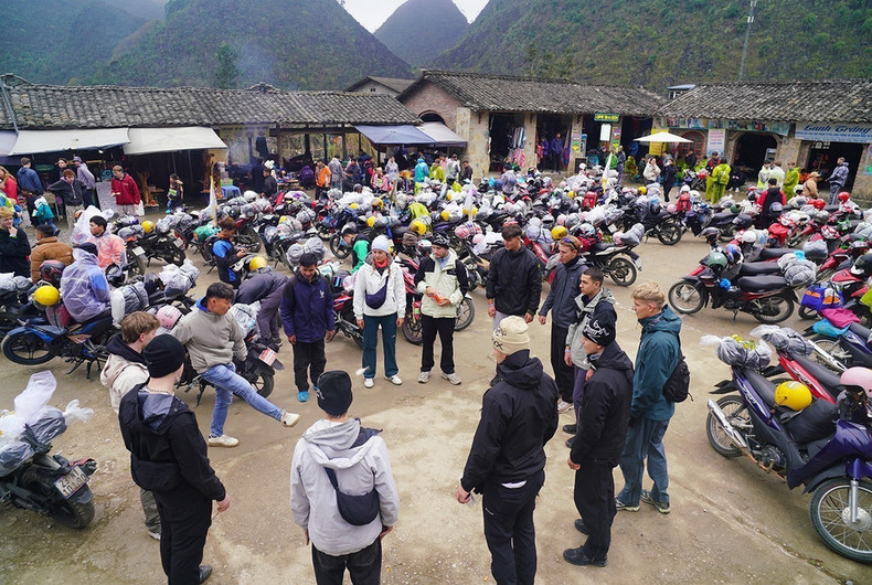 Los turistas internacionales juegan al volante durante un descanso en su viaje para explorar Ha Giang. Los turistas internacionales juegan al volante durante un descanso en su viaje para explorar Ha Giang.